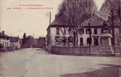 Carte postale ancienne Le Monument et les Ecoles — Jussac (Cantal)