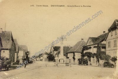 Carte postale ancienne Grande-Rue et la Fontaine — Dannemarie (Haut-Rhin)